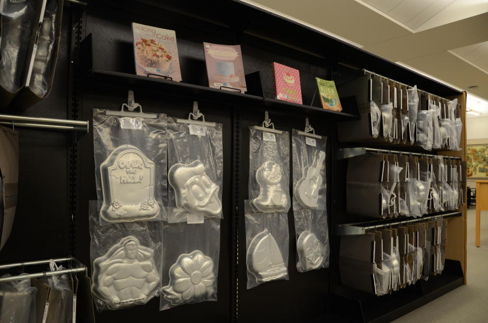 This July 25, 2019 photo shows the cake pan collection at the Akron-Summit County Public Library in Akron, Ohio. The collection was a popular addition to the library and patrons enjoy the chance to use the pans without purchasing them. Many of the options in the collection are cartoon characters suitable for a child's birthday, which also features tiered pans for wedding cakes and other celebrations. (Tim Hite/Akron-Summit County Public Library via AP)