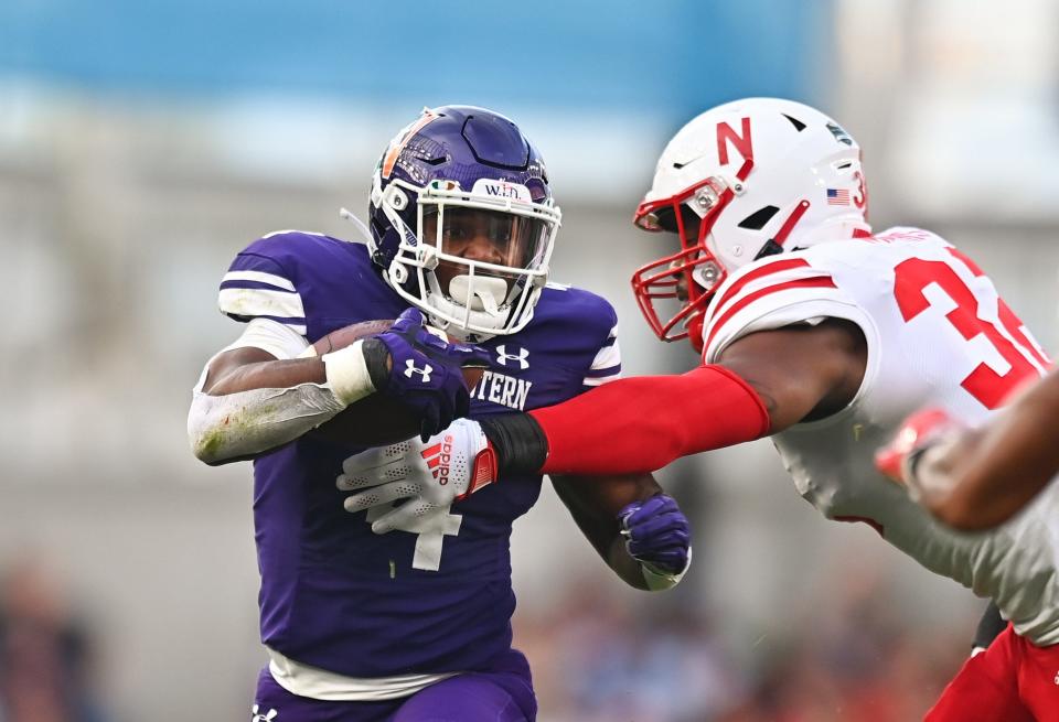 Aug 27, 2022; Dublin, IRELAND; Northwestern Wildcats running back Cam Porter is tackled by Nebraska Cornhuskers edge rusher Ochaun Mathis in the Aer Lingus college football series at Aviva Stadium.