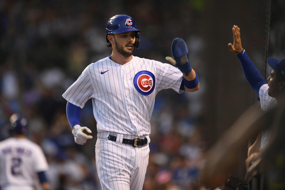 Chicago Cubs' Kris Bryant, front left, celebrates at the dugout after scoring on a David Bote single during the third inning of a baseball game against the Cincinnati Reds, Monday, July 26, 2021, in Chicago. (AP Photo/Paul Beaty)