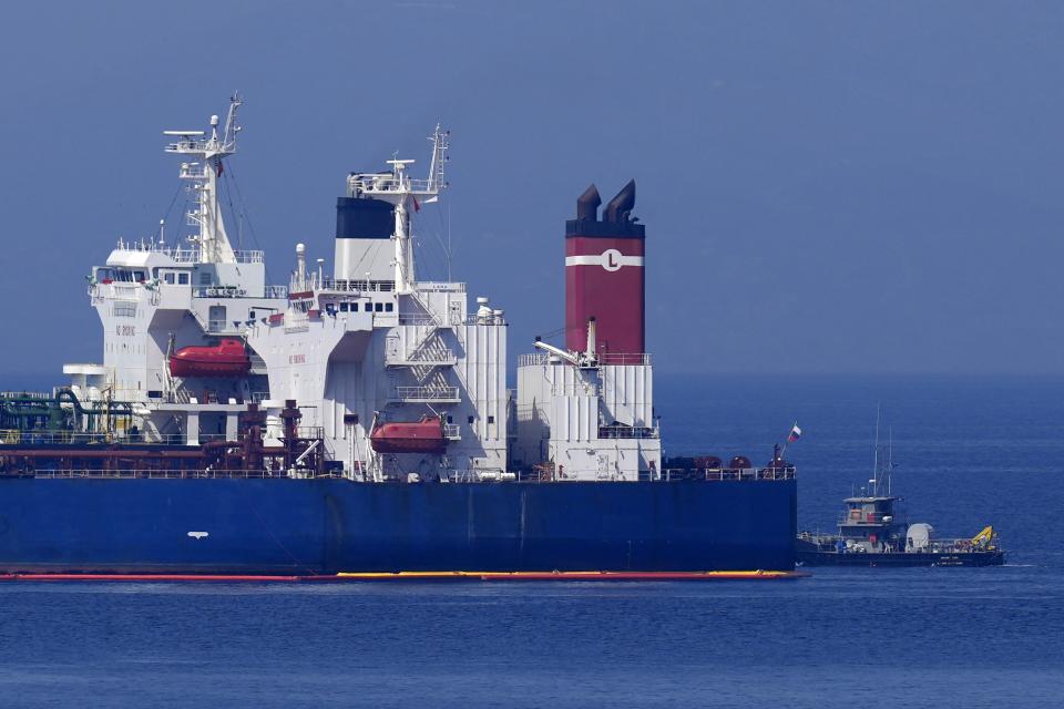 The Pegas tanker, that has recently changed its name to Lana, the blue one foreground, is seen off the port of Karystos on the Aegean Sea island of Evia, Greece, Friday, May 27, 2022. The crude oil cargo of the Iranian-flagged tanker that was stopped in Greek waters last month has been seized and is being transferred to another vessel following a request from the U.S., a Greek official said Thursday. (AP Photo/Thanassis Stavrakis)