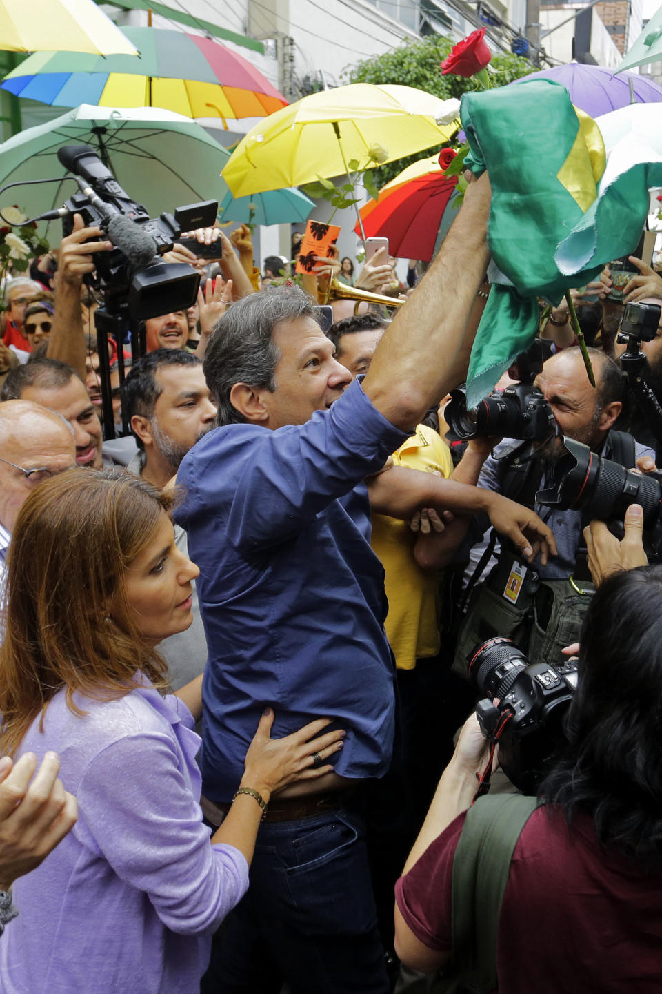 Workers' Party presidential candidate Fernando Haddad holds a Brazilian flag after casting his vote in the presidential runoff election in Sao Paulo, Brazil, Sunday, Oct. 28, 2018. Brazilian voters decide Sunday who will next lead the world's fifth-largest country, the left-leaning Haddad or far-right rival Jair Bolsonaro. (AP Photo/Nelson Antoine)