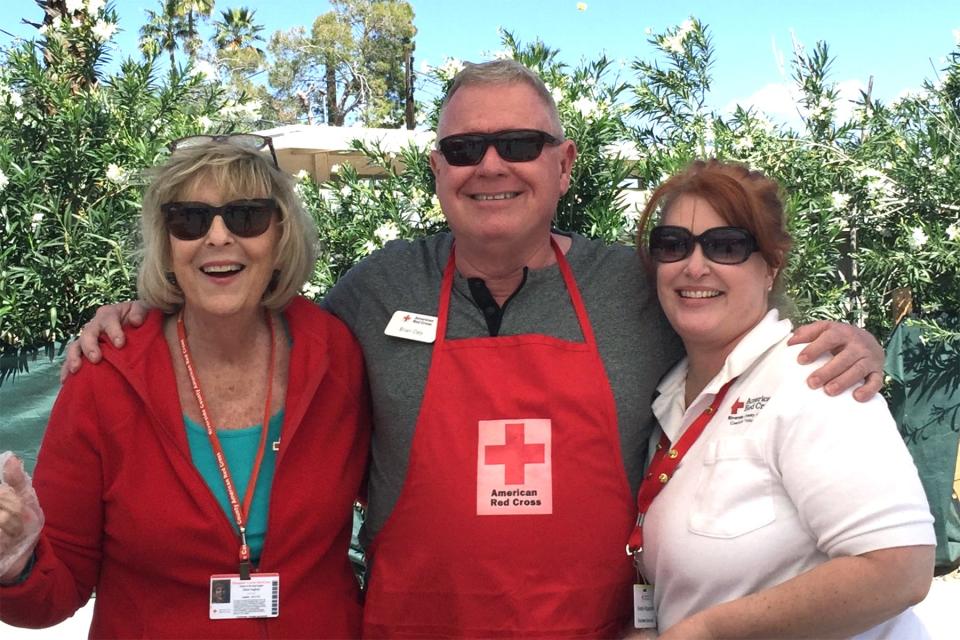 Eileen Hughes (left) and Brian Daly pose with a Red Cross volunteer.