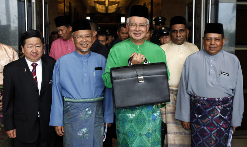 Malaysian Prime Minister and Finance Minister Najib Razak, center, holds a briefcase as he poses with Finance Minister II Ahmad Husni Mohamad Hanadzlah, second from left, Deputy Finance Minister Awang Adek, right, and Deputy Finance Minister Donald Lim before he leaves from Finance Ministry office in Putrajaya, Malaysia, Friday, Sept. 28, 2012, to Parliament House to unveil the Malaysia's 2013 budget. (AP Photo/Lai Seng Sin)