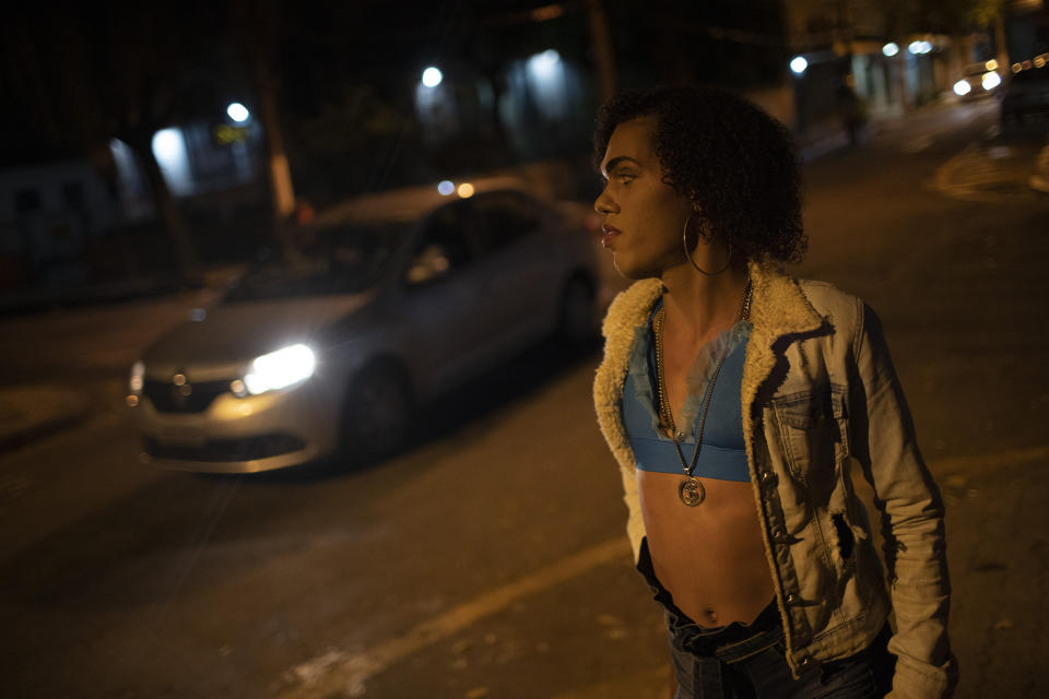 Transgender sex worker Alice Larubia waits for customers in Niteroi, Brazil, Saturday, June 27, 2020, amid the new coronavirus pandemic. She keeps hand sanitizer in her purse and wears a mask on public transport, but said she can’t while working. She earns around $15 per night, less than half her payday before the onset of the outbreak. “I’m scared,” she said. “I know I’m at risk.” (AP Photo/Silvia Izquierdo)