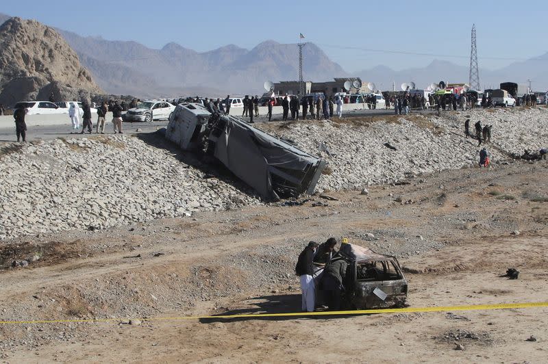 Police officers in civilian clothes survey the aftermath of a suicide bomb blast on a police patrol in Quetta