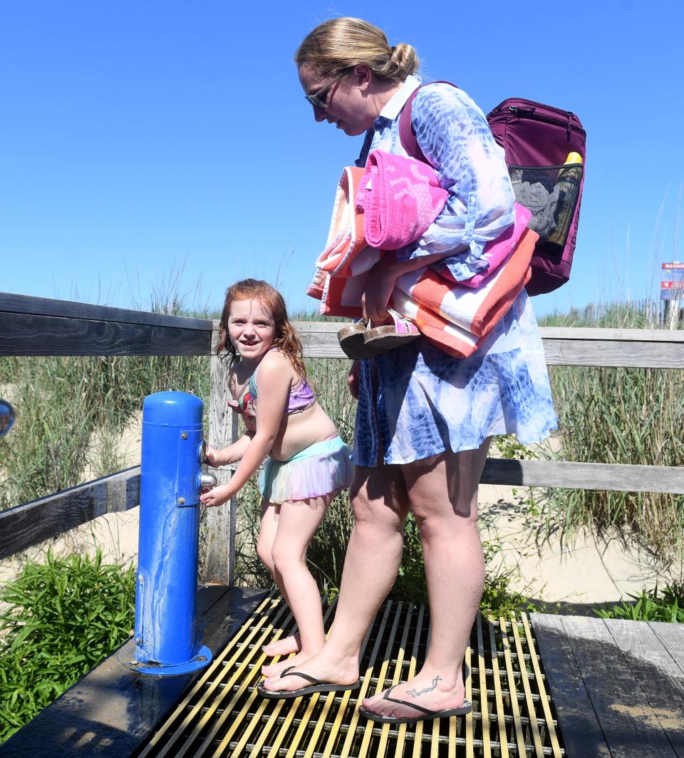 Melanie Green and her daughter Abigail wash off the sand after spending the day on the beach Thursday, June 17, 2021, in Bethany Beach, Delaware.