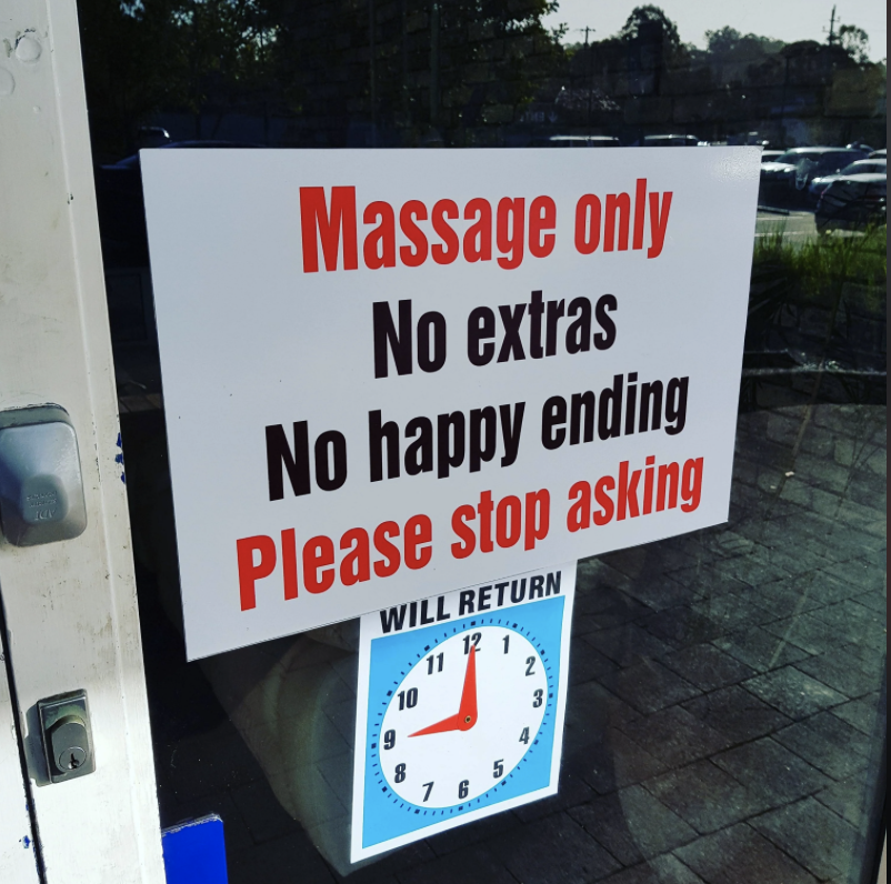 A sign on a door reads, "Massage only, No extras, No happy ending, Please stop asking." There is also a clock sign below indicating the return time