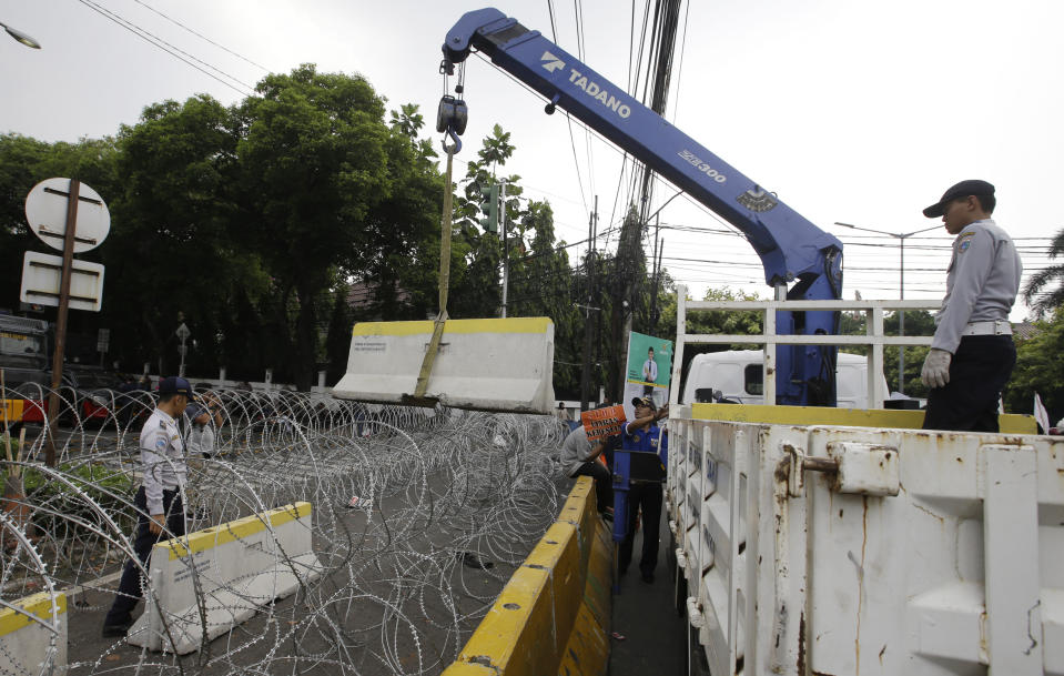 Officials put roadblocks near Election Commission building in Jakarta, Indonesia, Tuesday, May 21, 2019. Indonesia's President Joko Widodo has been elected for a second term, official results showed Tuesday, in a victory over a would-be strongman who aligned himself with Islamic hardliners. Thousands of police and soldiers are on high alert in the capital Jakarta, anticipating protests from Widodo's challenger Prabowo Subianto's supporters. (AP Photo/Achmad Ibrahim)