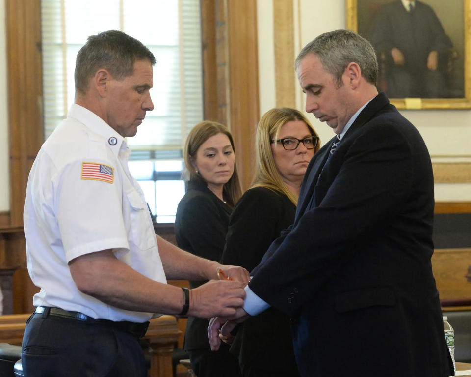 A court officer places handcuffs on Michael Schoener, after he was sentenced to serve 6 to 9 years in state prison, but they were soon after removed when his sentence was stayed and he walked out of Norfok County Superior Court in Dedham on Thursday, April 25, 2019.