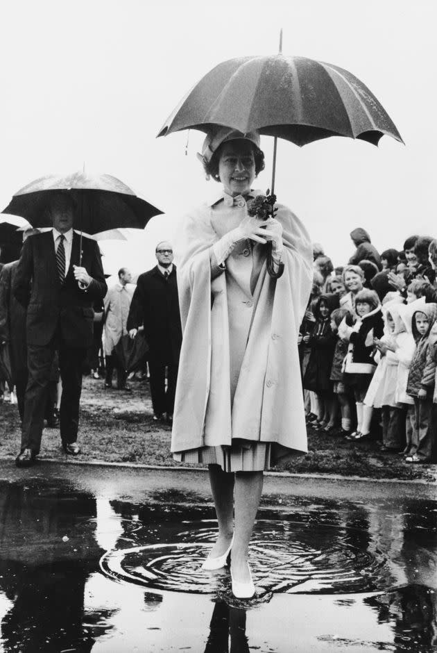 Queen Elizabeth II steps into a puddle during her visit to New Zealand in 1977. (Photo: Tim Graham Photo Library via Getty Images)