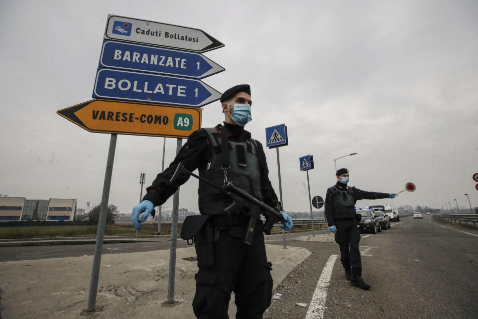 FILE - Carabinieri officers patrol one of the main access road to Bollate, in the outskirts of Milan, Italy. Italy’s northern Lombardy region, where Europe's coronavirus outbreak erupted last year, asked the national government Thursday to send more vaccines north to help stem a surge of new cases that are taxing the hospital system in the province of Brescia. Brescia, with a population of around 1.2 million, has seen its daily caseload go from the mid-100s at the start of February to 901 on Wednesday thanks in part to clusters of cases traced to the British variant. (AP Photo/Luca Bruno)