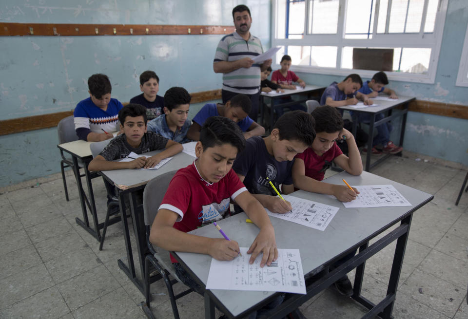 In this May 26, 2019 file photo, a teacher supervises while Palestinian school children attend a final exam during the last day of the school year, at the United Nations Relief and Works Agency for Palestine Refugees in the Near East, UNRWA, Hebron Boys School, in the West Bank city of Hebron. The head of the U.N. agency that helps 5.3 million Palestinian refugees says it is mobilizing to replenish a $211 million shortfall in the face of U.S. funding cuts. Pierre Kraehenbuehl said Monday, June 17, 2019, in Jordan that UNRWA will start running out of money if it does not receive significant commitments at its pledging conference next week (AP Photo/Nasser Nasser, File)