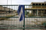 Una bandera griega descansa sobre la puerta de una fábrica de aceite de cocina que se cerró en 1996 en la ciudad de Elefsina.