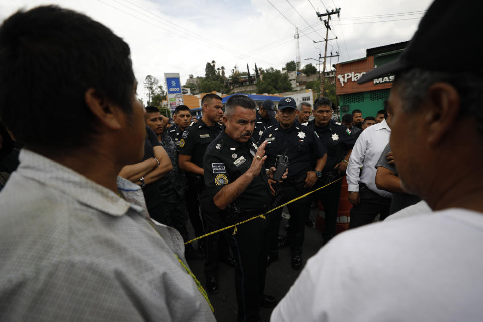 A federal police officer talks with angry drivers insisting that they be let through a police roadblock that had already stopped traffic for more than seven hours, on the highway linking Mexico City with Pachuca, in Ecatepec, Wednesday, July 3, 2019. Hundreds of Mexican federal police were in open revolt Wednesday against plans to absorb them into the newly formed National Guard.(AP Photo/Rebecca Blackwell)
