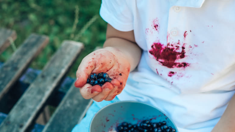 child with blueberry stain on shirt
