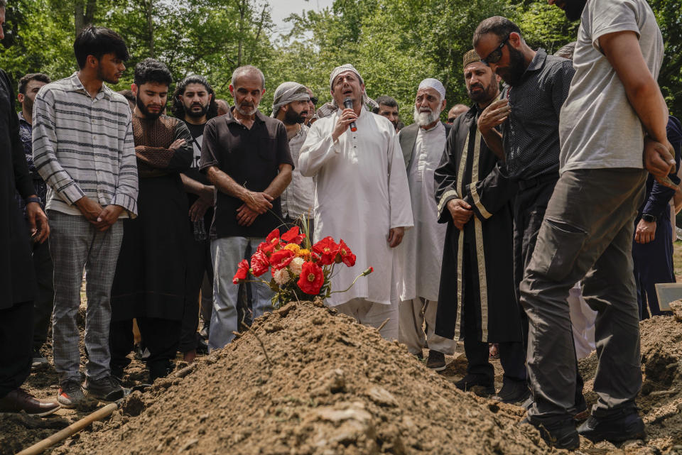 Friends and family pray over the grave of Nasrat Ahmad Yar, 31, during a funeral service at the All Muslim Association of America cemetery on Saturday, July 8, 2023 in Fredericksburg, Va. Ahmad Yar, an Afghan immigrant who worked as an interpreter for the U.S. military in Afghanistan, was shot and killed on Monday, July 3, while working as a ride-share driver in Washington. (AP Photo/Nathan Howard)