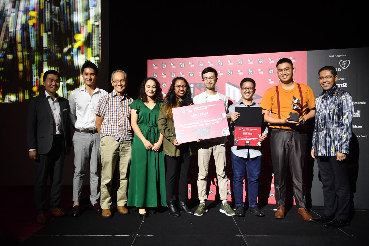 Senior Minister of State for Defence and Foreign Affairs Maliki Osman (right) with Jastine Tan (in orange), winner of the ciNE65 Movie Makers Awards for the film "My Homeland: A Photography Project by Grandpa Chen". (PHOTO: Nexus, MINDEF)