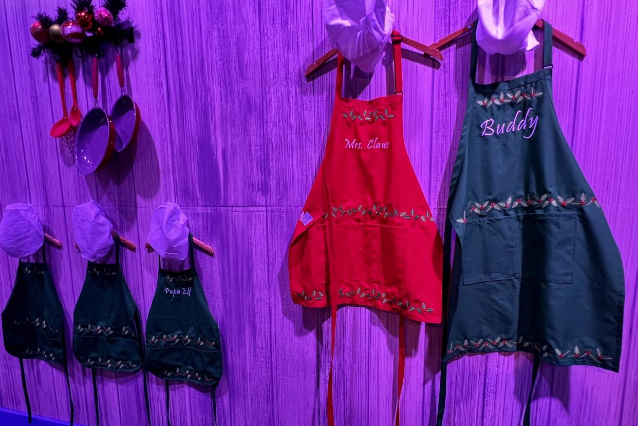 Find Buddy and Papa Elf-sized aprons hanging on the wall in the display's kitchen area. (Photo: Terri Peters)