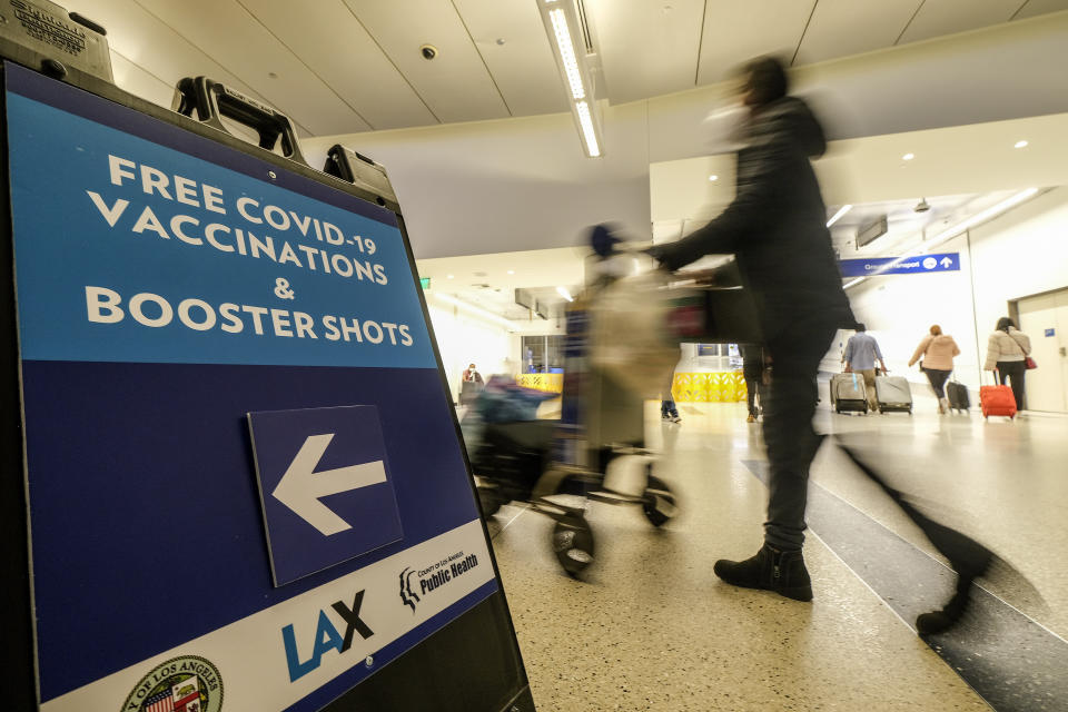 A Free COVID-19 Vaccination and Booster Shots sign is posted at the Los Angeles International Airport in Los Angeles, Wednesday Dec. 22, 2021. People traveling during the holiday season can get free COVID-19 vaccinations and booster shots at LAX on two consecutive Wednesdays -- today and Dec. 29. The pop-up clinic, located at the Lower/Arrivals Level of the Tom Bradley International Terminal, will be open from 11 a.m. to 5 p.m. on the two days. (AP Photo/Ringo H.W. Chiu)