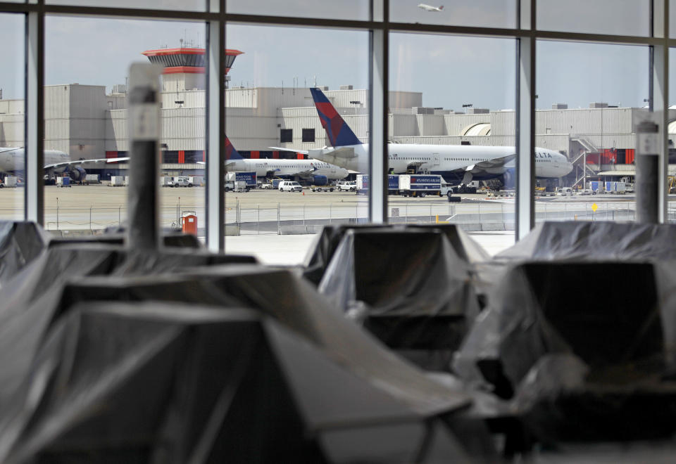 The existing international terminal is seen in the background as chairs sit covered in plastic in the new Maynard Holbrook Jackson Jr. International Terminal at Atlanta's airport Wednesday, March 28, 2012. The new $1.4 billion international terminal at the world's busiest airport will be a sleek launching pad for millions of passengers that’s designed to help Atlanta grab a growing share of the lucrative market for global travelers. (AP Photo/David Goldman)