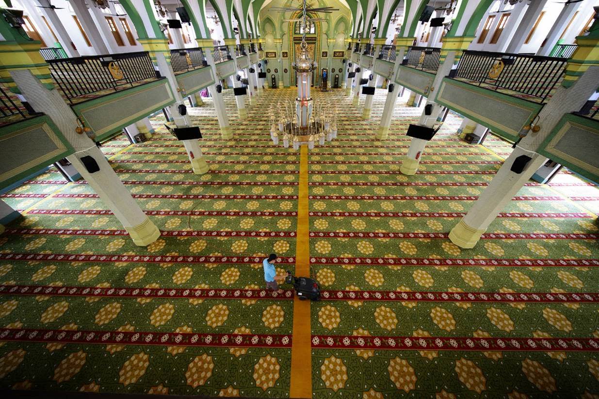 A worker cleaning the carpets at Sultan Mosque. (PHOTO: Muis)