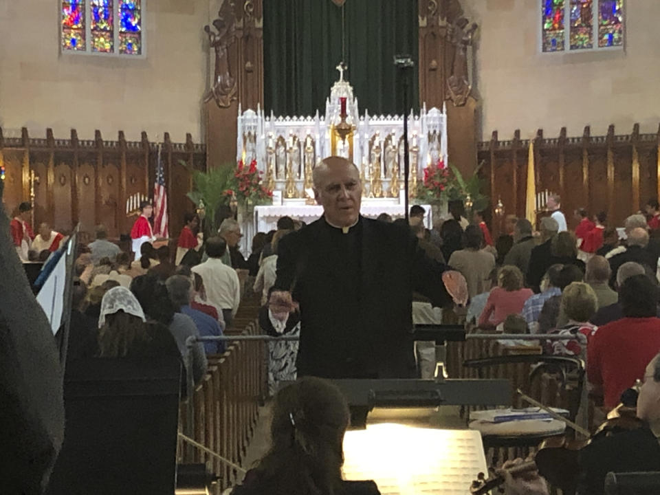 FILE - In this June 9, 2019 file photo, Father Eduard Perrone conducts a choir during a Mass at The Assumption of the Blessed Virgin Mary Church in Detroit. Perrone was a co-founder of a small nonprofit organization called Opus Bono Sacerdotii which has provided money, shelter, transport, legal help and other support to priests accused of sexual abuse. (AP Photo/Paul Sancya)