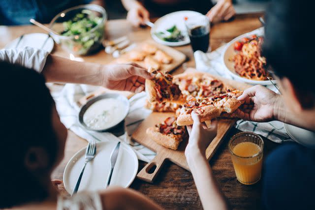 <p>Getty</p> People eating pizza