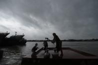 A family collects drinking water froma water pump ahead of the expected landfall of cyclone Amphan, in Khulna on May 20, 2020. - Several million people were taking shelter and praying for the best on Wednesday as the Bay of Bengal's fiercest cyclone in decades roared towards Bangladesh and eastern India, with forecasts of a potentially devastating and deadly storm surge. Authorities have scrambled to evacuate low lying areas in the path of Amphan, which is only the second "super cyclone" to form in the northeastern Indian Ocean since records began. (Photo by Munir uz Zaman / AFP) (Photo by MUNIR UZ ZAMAN/AFP via Getty Images)