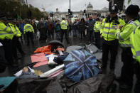 Extinction Rebellion climate change protesters lie with their arms locked together blocking a road at the bottom of Trafalgar Square in London, Friday, Oct. 11, 2019. Some hundreds of climate change activists are in London during a fifth day of protests by the Extinction Rebellion movement to demand more urgent actions to counter global warming. (AP Photo/Matt Dunham)