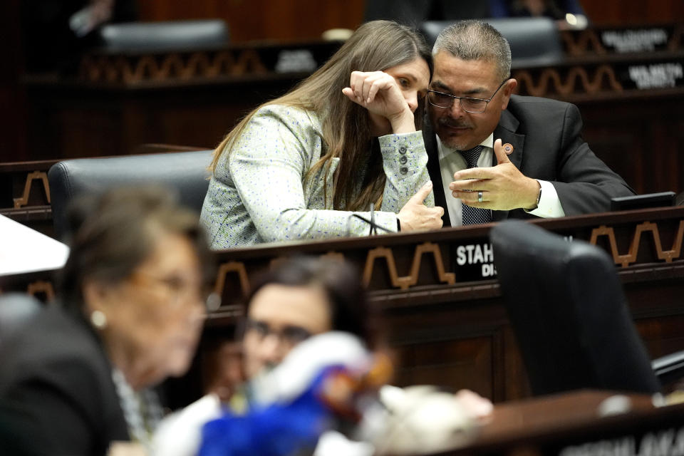 Arizona State Rep. Lupe Contreras, D, right, speaks with Stephanie Stahl Hamilton, D, on the House floor, Wednesday, April 17, 2024, at the Capitol in Phoenix. House Republicans have again blocked an effort for the chamber to take up legislation that would repeal Arizona’s near-total ban on abortions. (AP Photo/Matt York)