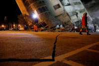 Rescue personnel search a collapses building after an earthquake hit Hualien, Taiwan February 7, 2018. REUTERS/Tyrone Siu