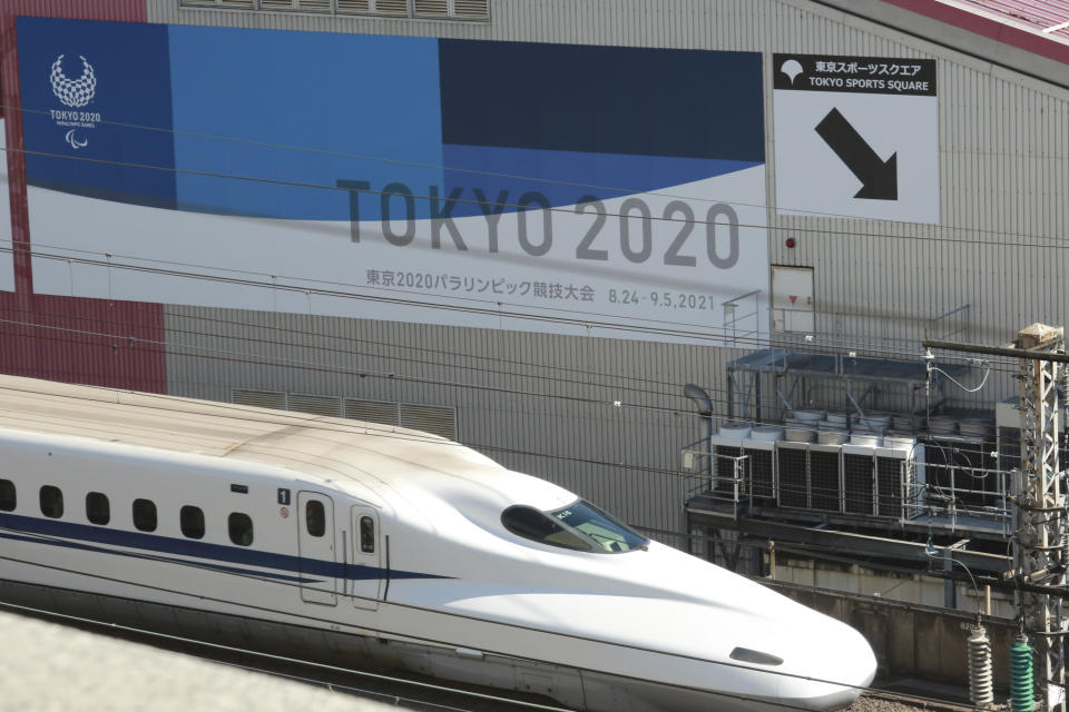 A Shinkansen bullet train moves past a poster for the Paralympic Games, scheduled for the summer of 2021, in Tokyo, Feb. 24, 2021. / Credit: Koji Sasahara/AP