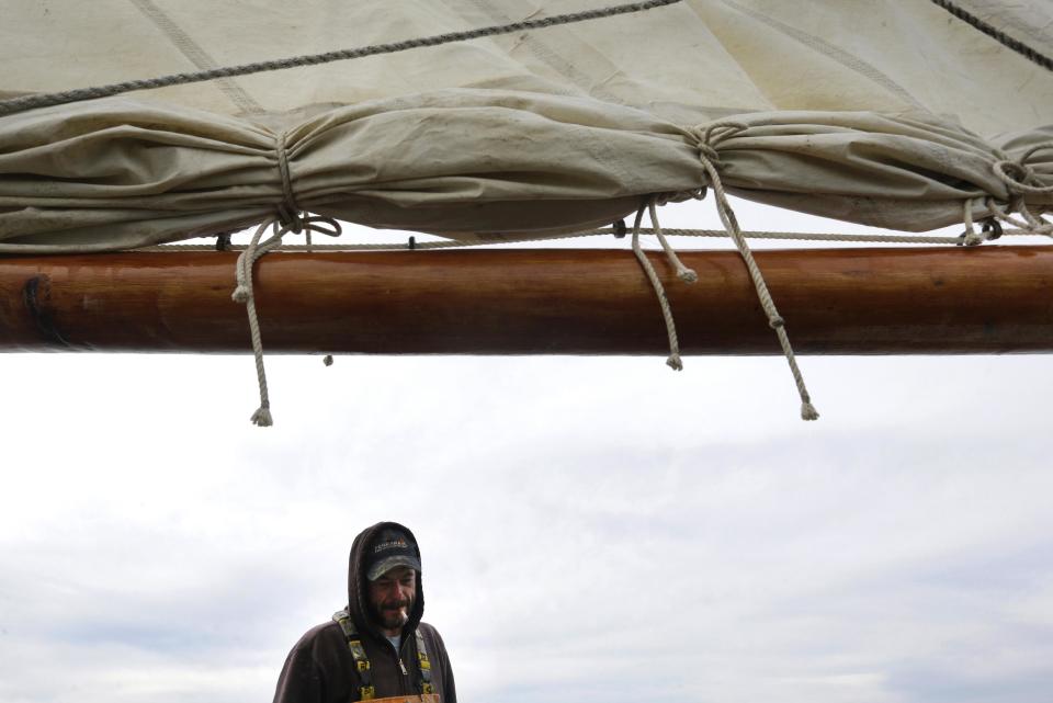 In this Dec. 20, 2013 picture, Shawn Sturgis pauses from dredging oysters to smoke a cigarette while sailing on the skipjack Hilda M. Willing in Tangier Sound near Deal Island, Md. (AP Photo/Patrick Semansky)