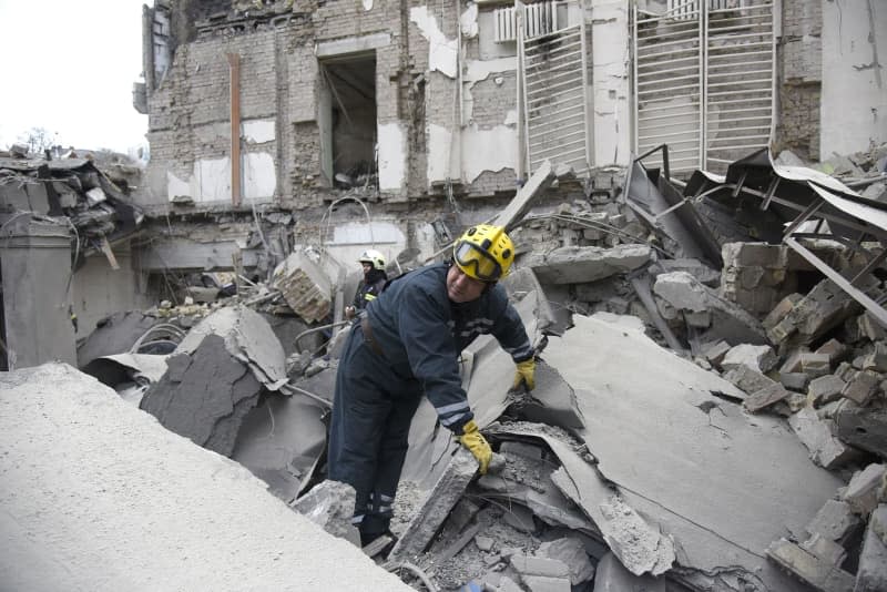 Rescuers search a destroyed building following a missile attack by the Russian army on Kiev. -/Ukrinform/dpa