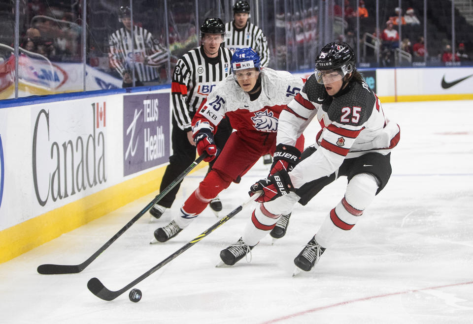 FILE - Canada's Owen Power (25) is chased by Czech Republic's Vojtech Jirus (25) during second-period IIHF world junior hockey championship game action in Edmonton, Alberta, Sunday, Dec. 26, 2021. USA Hockey and Hockey Canada are eyeing several college players to play at the Olympics after the NHL decided not to participate in Beijing. Owen Power could suit up for Canada. (Jason Franson/The Canadian Press via AP, File)