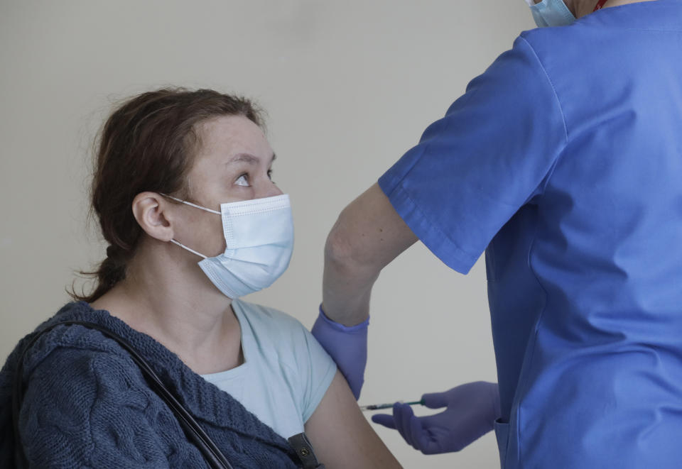 A Polish teacher is vaccinated against the coronavirus with the AstraZeneca vaccine in Krakow, Poland, Friday Feb. 12, 2021. As Poland began vaccinating teachers on Friday, many say they are unhappy that they are getting AstraZeneca vaccines against the coronavirus, rather than the Pfizer shots earmarked for health care workers and the elderly. Nearly a year into the pandemic, many Europeans and others globally are desperate to get vaccinated and return to normal life. But many don't want just any vaccine. (AP Photo/Czarek Sokolowski)