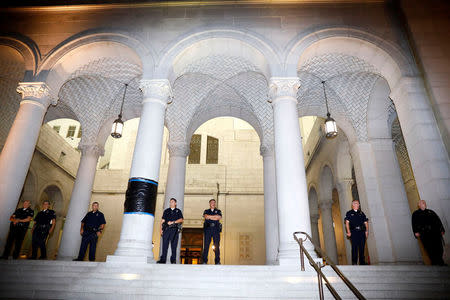 LAPD officers stand at an entrance next to a pillar that had been graffitied as demonstrators protest outside of City Hall following the election of Republican Donald Trump as President of the United States in downtown Los Angeles, California November 10, 2016. REUTERS/Patrick T. Fallon