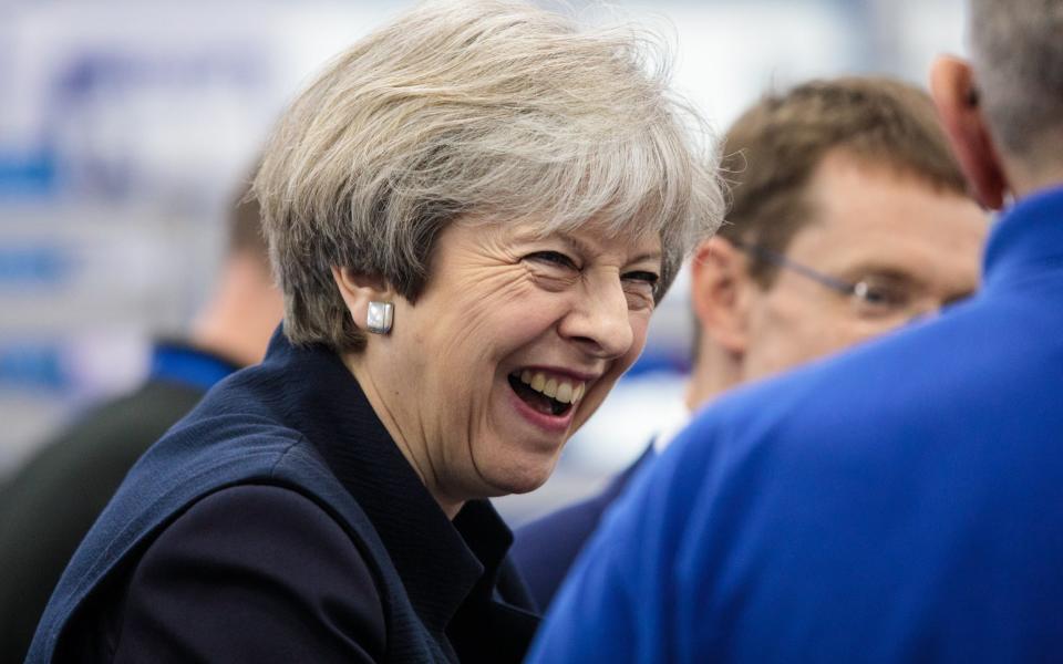 British Prime Minister Theresa May shares a laugh with a worker as she tours the UTC Aerospace Systems factory during a campaign visit on May 6, 2017 in Wolverhampton - Credit: Jack Taylor/Getty