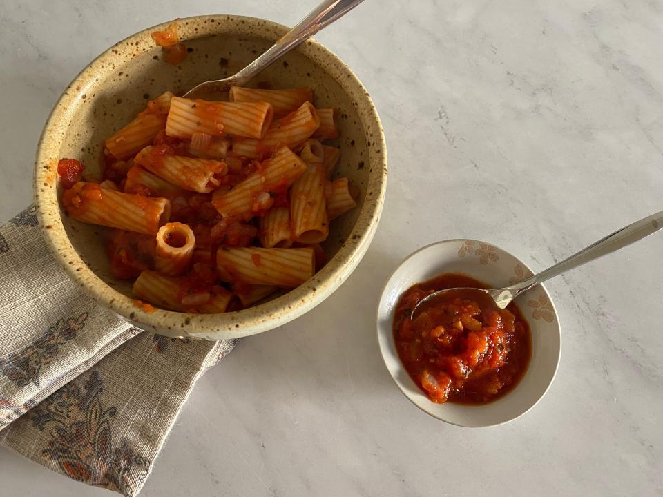 Pasta with marinara sauce by a smaller bowl of a chunky marinara sauce