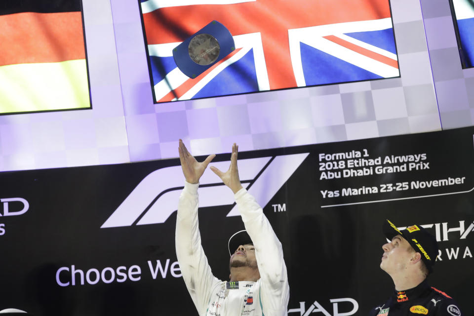 Mercedes driver Lewis Hamilton of Britain celebrates his victory flanked by third place Red Bull driver Max Verstappen of the Netherlands on the podium, after the Emirates Formula One Grand Prix at the Yas Marina racetrack in Abu Dhabi, United Arab Emirates, Sunday, Nov. 25, 2018.(AP Photo/Luca Bruno)