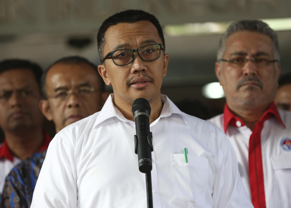 Indonesian Youth and Sports Minister Imam Nahrawi, center, speaks to the media during a press conference in Jakarta, Indonesia, Thursday, Sept. 19, 2019. Nahrawi has stepped down from his position after being named a bribery suspect by the country's anti-graft commission. (AP Photo/Tatan Syuflana)