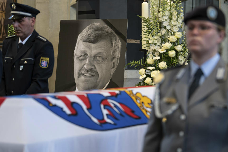 FILE-In this June 13, 2019 file photo a picture of Walter Luebcke stands behind his coffin during the funeral service in Kassel, Germany. German authorities say they have arrested a 45-year-old man in connection with their investigation into the slaying of a regional official from Chancellor Angela Merkel’s party. (Swen Pfoertner/dpa via AP)