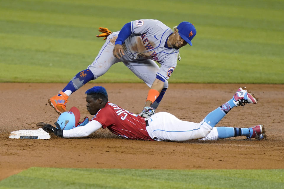 Miami Marlins' Jazz Chisholm Jr. is tagged out by New York Mets shortstop Francisco Lindor on an attempted steal of second during the first inning of a baseball game Friday, May 21, 2021, in Miami. (AP Photo/Lynne Sladky)