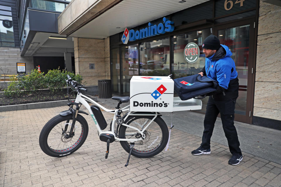 BOSTON, MA - MARCH 25: Javanshir Hajizada gets ready for a bicycle delivery for Domino's Pizza, which is hiring drivers, on March 25, 2020 in Boston. There have been an uptick in deliveries since many restaurants have completely closed to prevent the spread of coronavirus. (Photo by David L. Ryan/The Boston Globe via Getty Images)