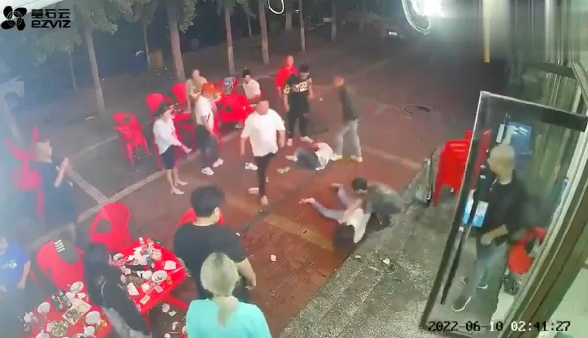 Two women lie on the ground after being assaulted by a group of men outside a restaurant in the northeastern city of Tangshan (via REUTERS)