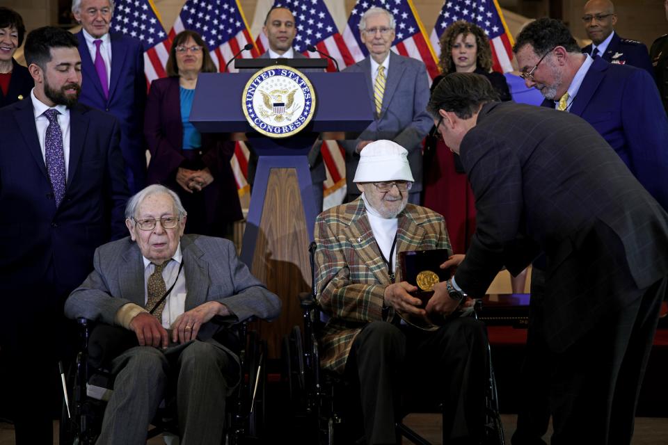 U.S. Speaker of the House Rep. Mike Johnson (R-LA) presents the Congressional Gold Medal to veteran of the Ghost Army Bernie Bluestein as fellow Ghost Army veteran Seymour Nussenbaum (L) attends the event during a presentation ceremony at the Emancipation Hall of the Capitol Visitor Center on March 21, 2024 on Capitol Hill in Washington, DC. The Congressional Gold Medal ceremony was held to honor the 23rd Headquarters Special Troops and the 3133rd Signal Services Company, known collectively as the Ghost Army.