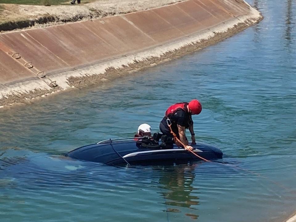 Firefighters from CalFire in Indio attach cables to a car that drove into the All-American Canal at Terra Lago Golf Resort in Indio. The driver of the car was rescued by a golfer and a tournament officials who dove into the canal.