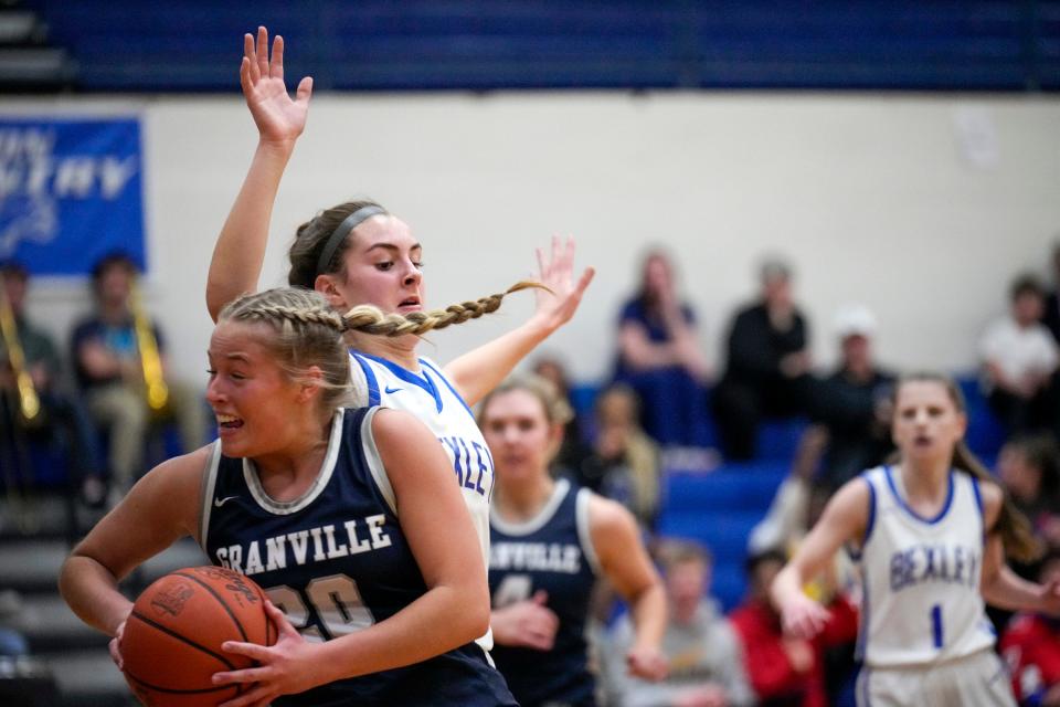 Granville's Ella Hoover (20) dodges around Bexley's Sofia Sheridan (10) during the first quarter of the girls basketball game between Granville and Bexley at Bexley High School on Tuesday night.