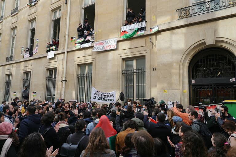 Los estudiantes hablan con la prensa frente al edificio de la universidad