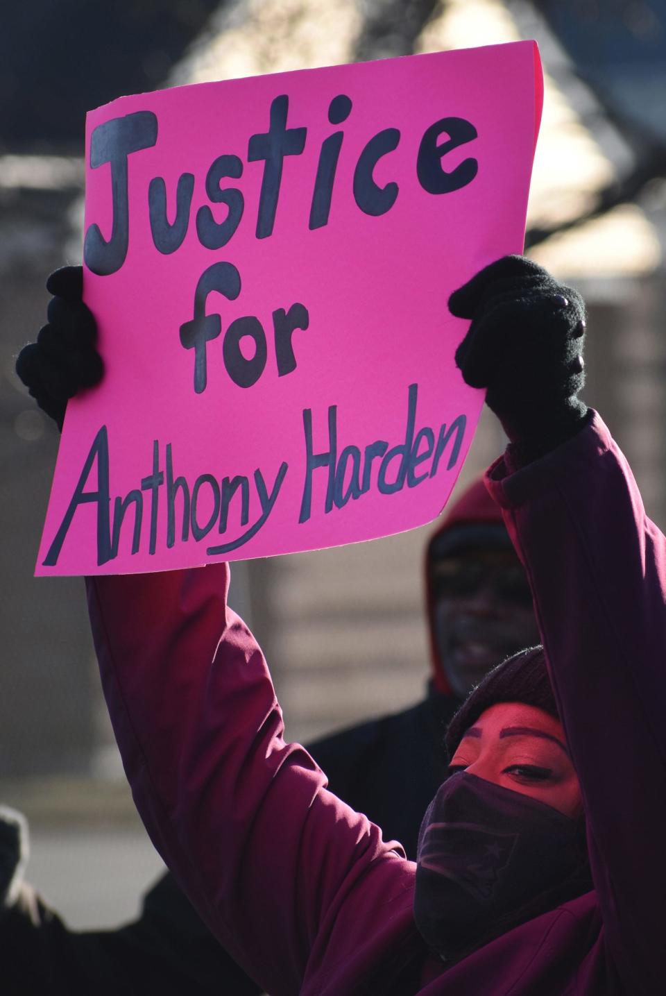 A woman holds up a sign at a rally in Fall River's Britland Pak Saturday to demand police transparency in the fatal police shooting of Anthony Harden. 